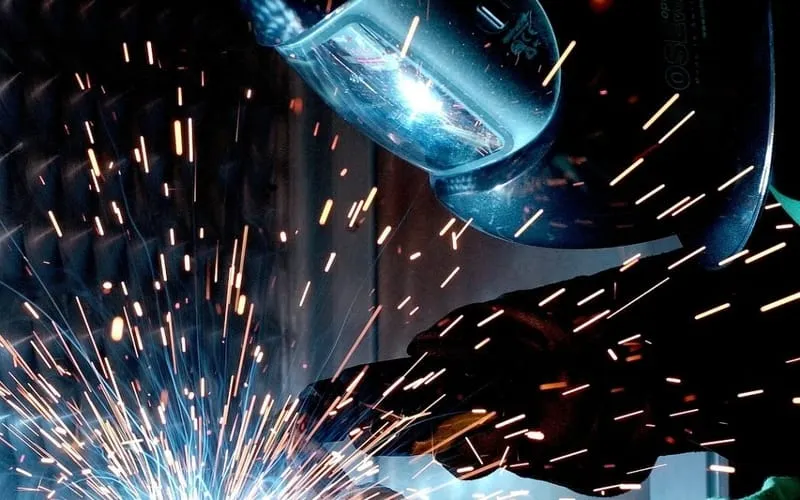 guy welding a window well cover